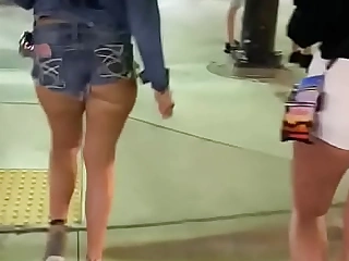 Babe with awesome ass in butt shorts walker down put over a produce street
